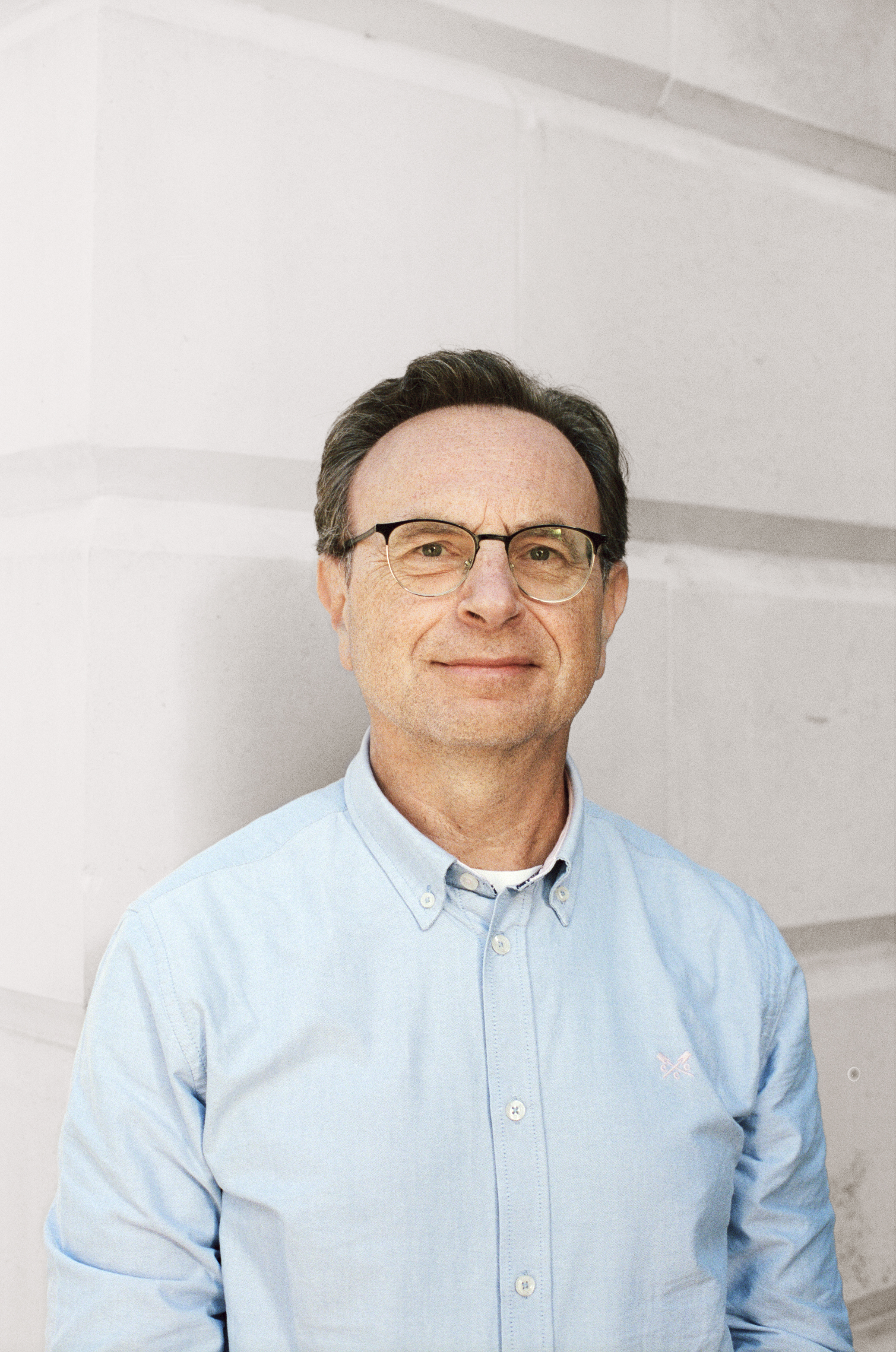 A photo of Paolo Toccaceli smiling in front of a white wall.